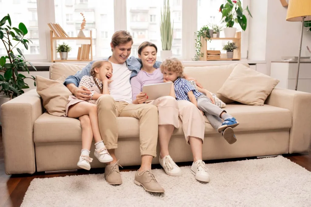 A happy family relaxing together on a sofa in a clean and organized living room