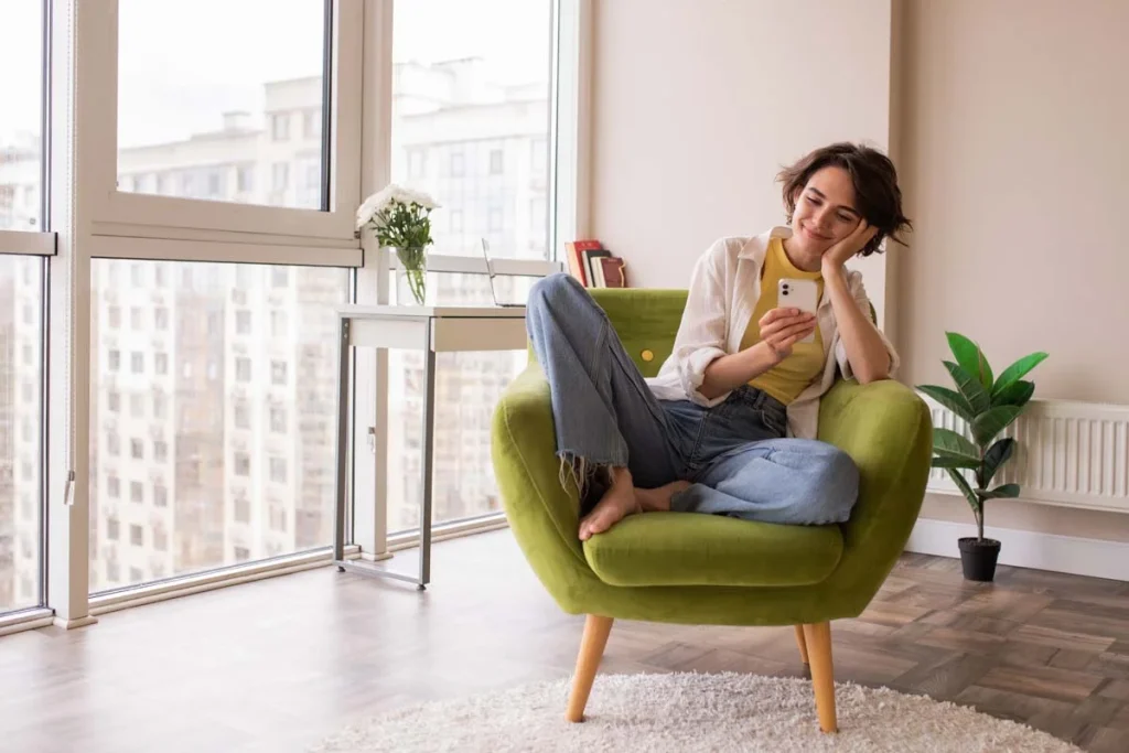A happy homeowner relaxing on a couch in a freshly cleaned living room