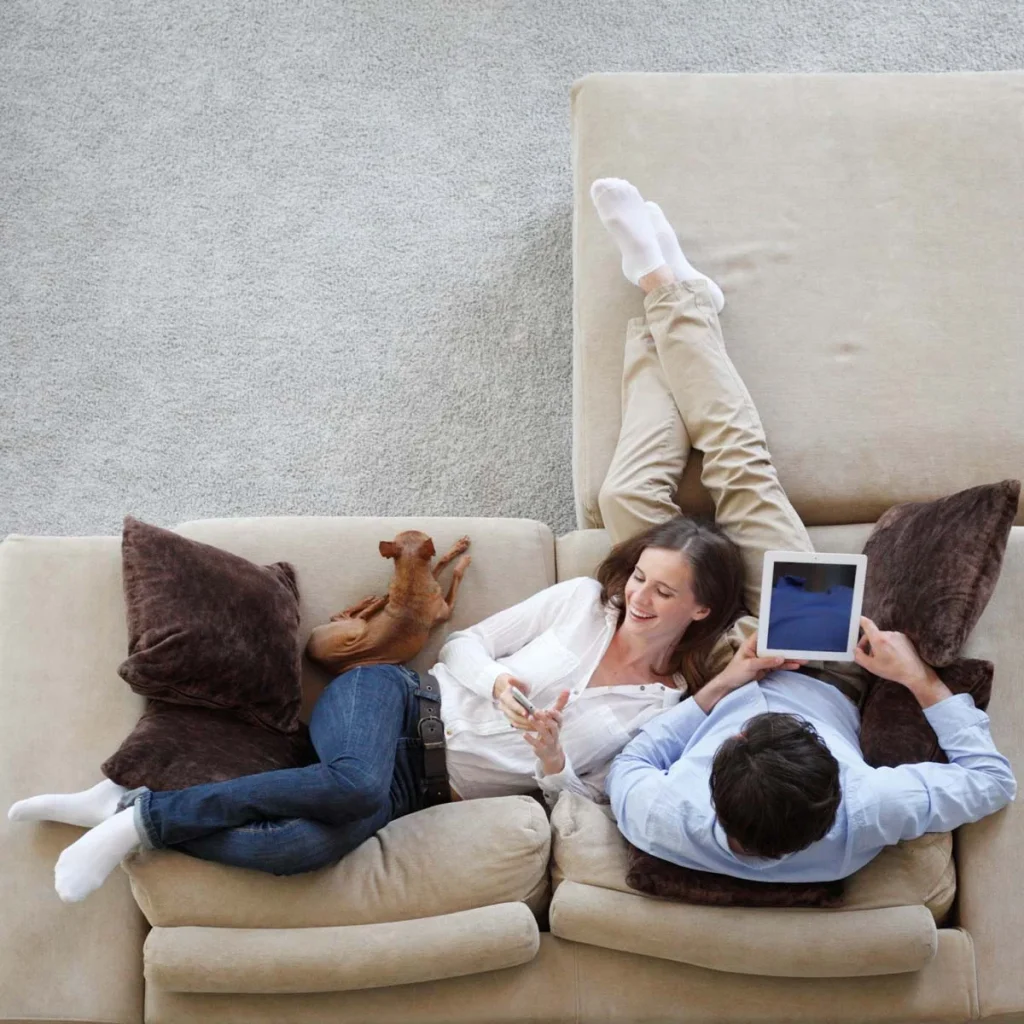 Couple relaxing on the sofa with a tablet in a freshly cleaned living room