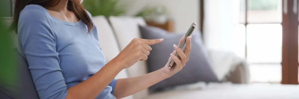 Hands holding a smartphone to request a house cleaning service quote online