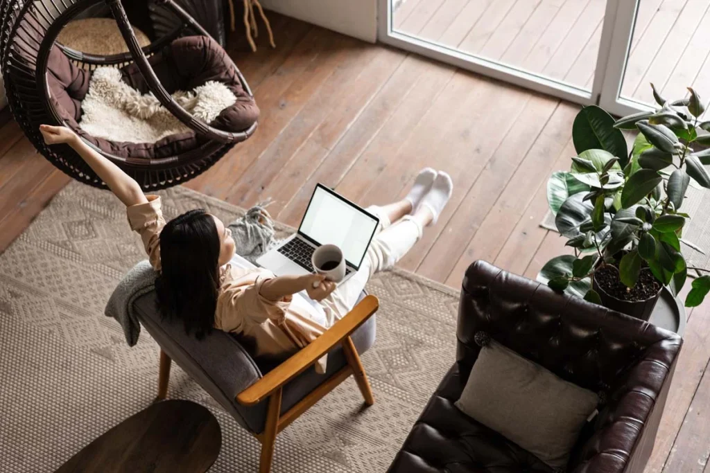 Overhead view of a relaxed woman on her laptop, scheduling a visit from a professional cleaning company